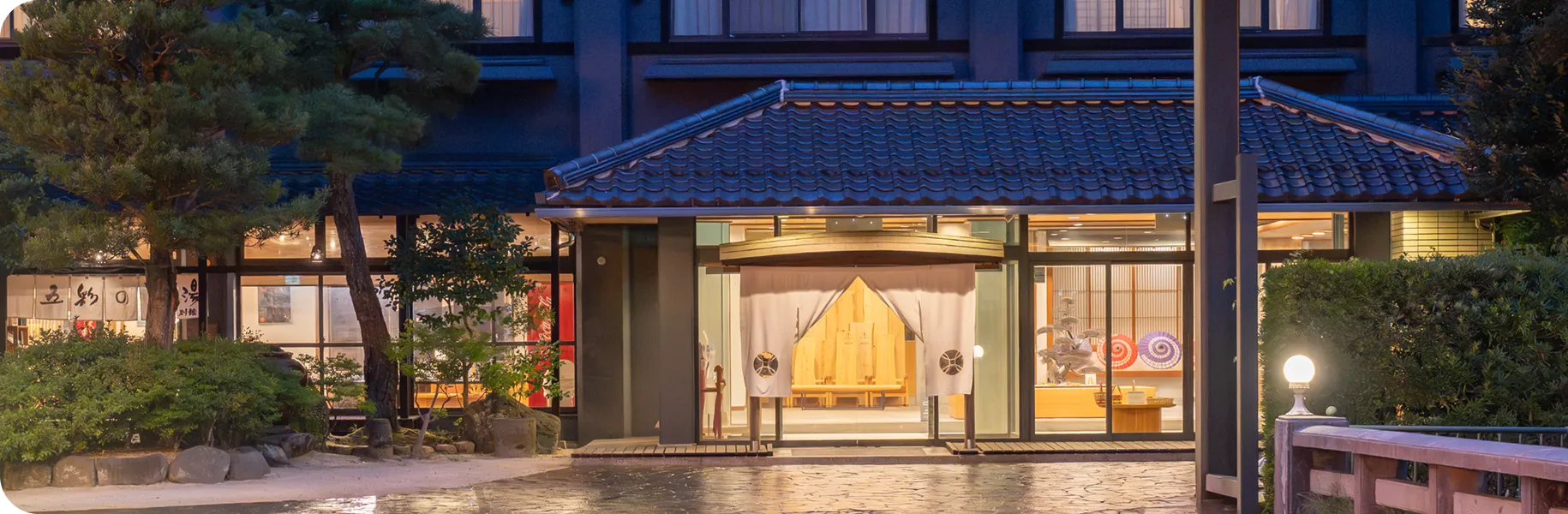 暖かい明かりが灯る「玉造温泉 RYOKAN OQOQ」のエントランス 