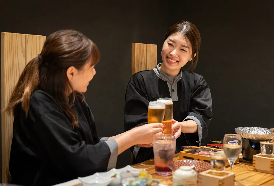 お料理を前に生ビールで乾杯する女性