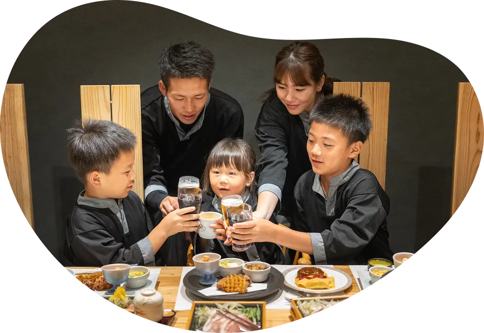 お小正料理を前に笑顔で乾杯するご家族