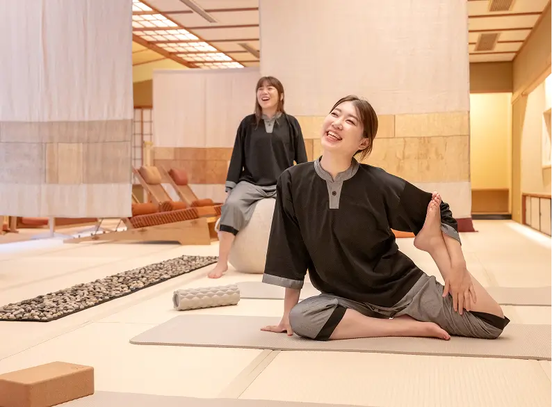 OQOQのすこやか広間でヨガを楽しむ女性