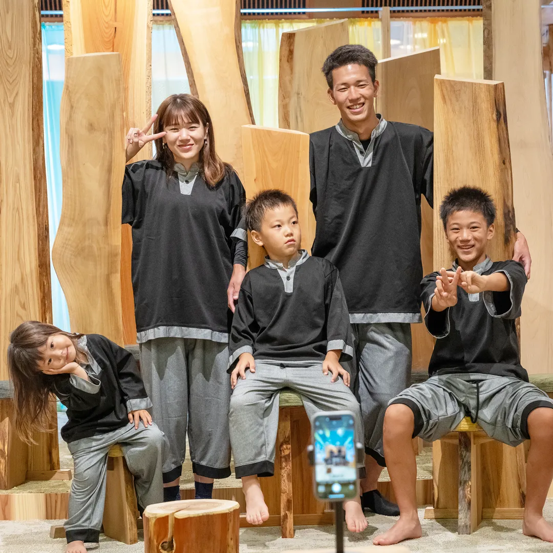 木製の森のシンボルチェアで笑顔の家族