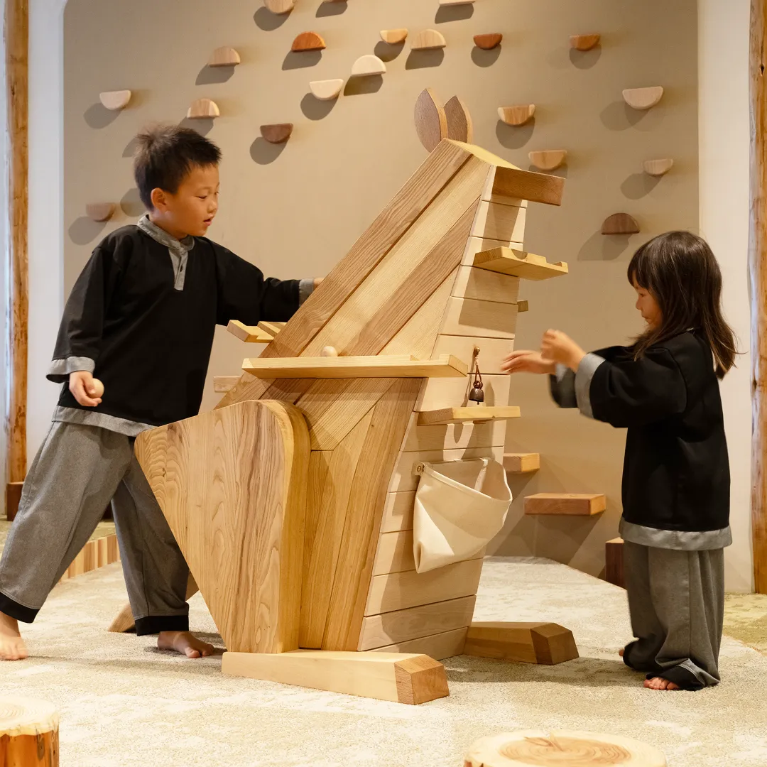 木製の転がるカンガルーで遊ぶこどもたち