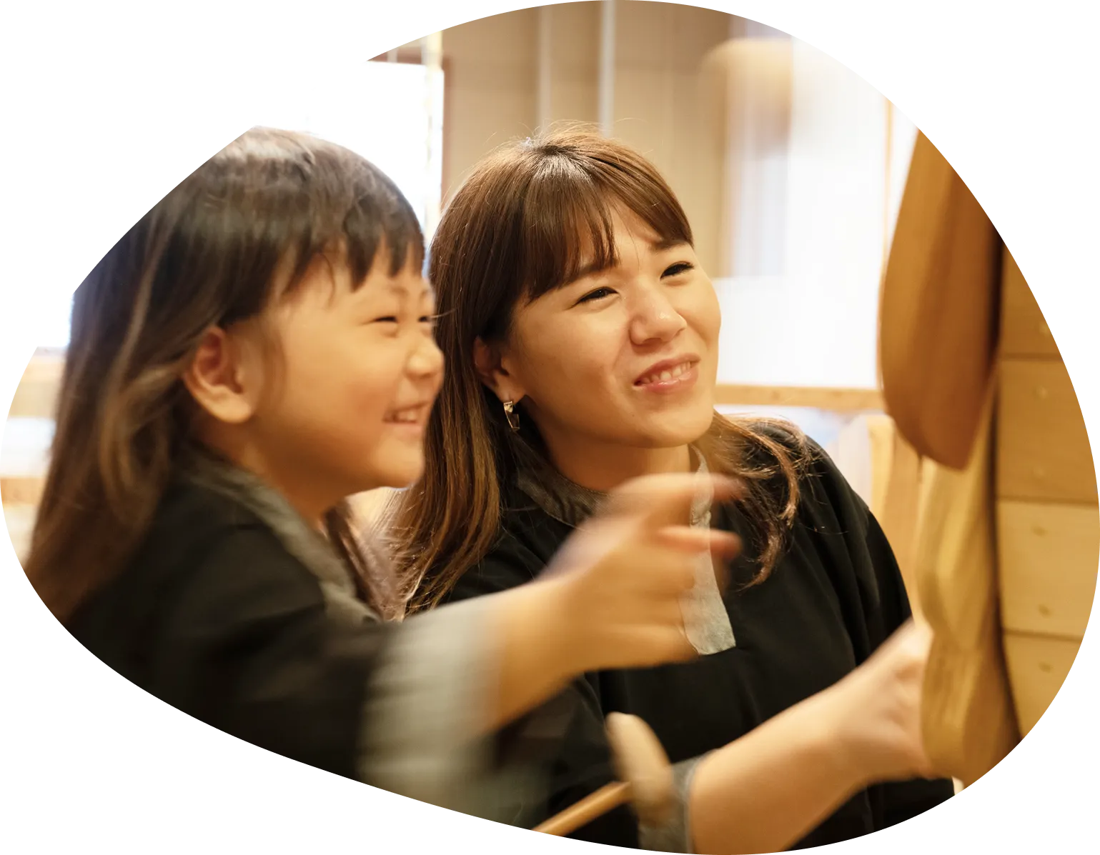 木製の遊具で楽しそうに遊ぶ親子