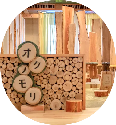 丸太や木材を多用した、温かみのあるキッズスペースの画像です。「オクモリ」という文字が書かれた丸太の看板があり、木のぬくもりが感じられる空間であることが伝わります。