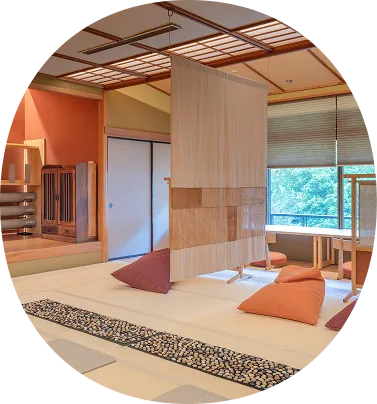 畳の部屋にビーズクッションが置かれた、くつろぎスペースの画像です。中央には間仕切りのような大きな布が吊るされており、落ち着いた照明でゆったりとリラックスできる雰囲気が伝わってきます。