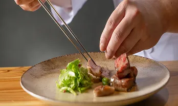 繊細な盛り付けが美しい、シェフこだわりの一品。丁寧に調理された肉料理が食欲をそそります。