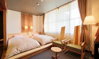 木のぬくもりに包まれた、心地よいツインルーム。小上がりのようなベッドと、窓から差し込む光が、安らぎのひとときを演出します。