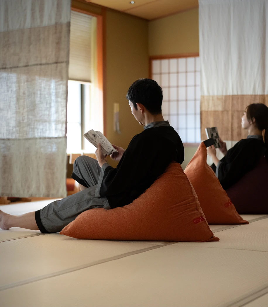 カフェラウンジで飲み物を片手に笑顔で会話する男女の画像です。自然光が差し込む明るく開放的な空間で、リラックスしたひとときを過ごしている様子が伝わってきます。