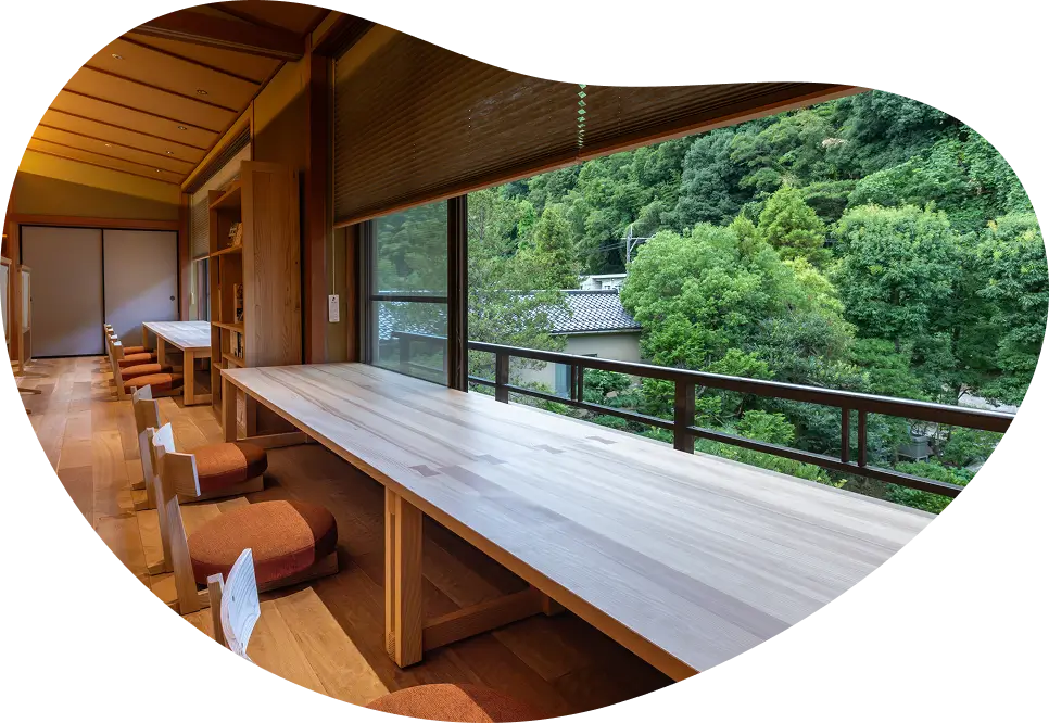 OQOQの湯上りどころ。開放的な窓の向こうに森を感じながら、木製のカウンターと座椅子でくつろげるスペース