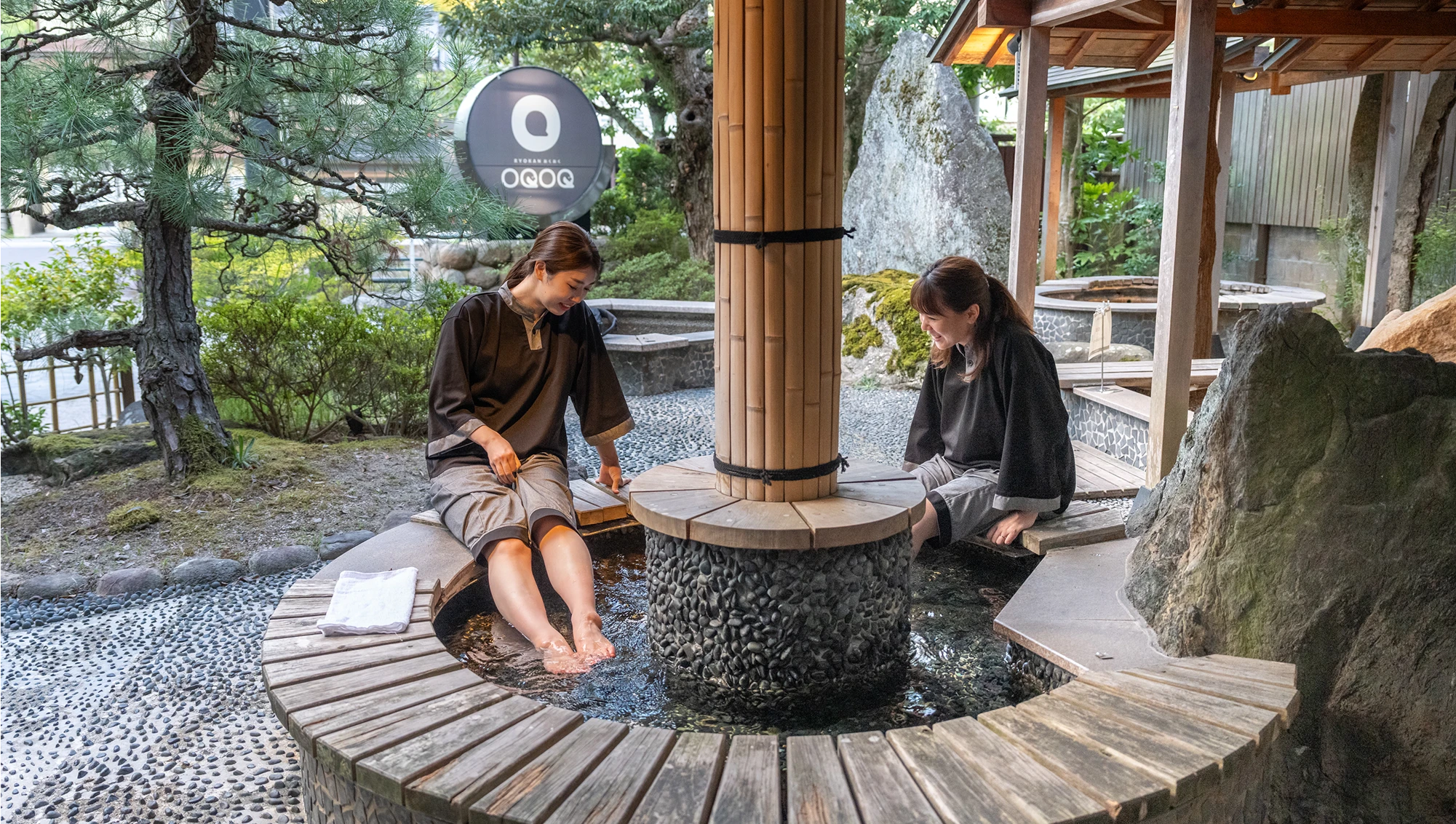 作務衣でOQOQの足湯を楽しむ女性